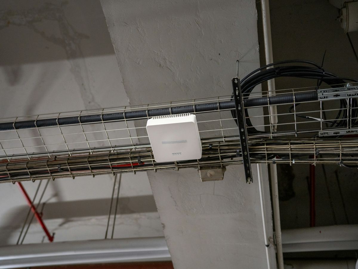 Een wifi-toegangspunt op een kabelgoot aan het plafond