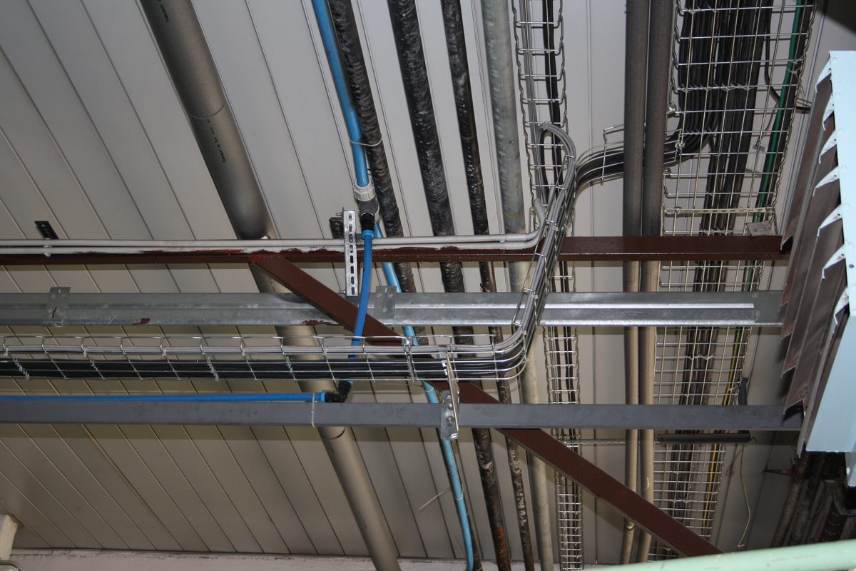 Draadgoten met kabels netjes langs het plafond, met leidingen ernaast